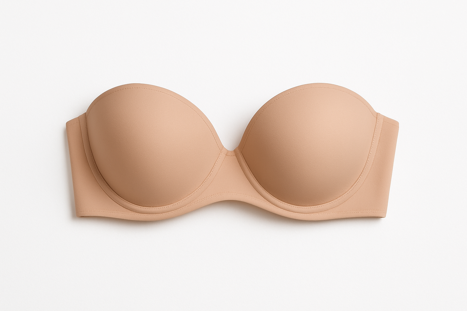 Opis alt tekstu: Biustonosz bardotka w beżowym kolorze, bez ramiączek, na białym tle.